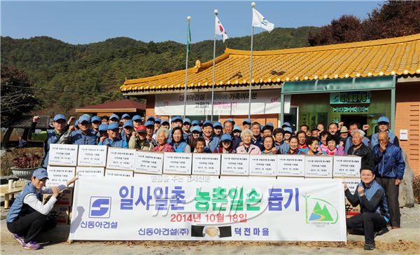 신동아건설 임직원들이 자매결연 한 강원 영월군 덕전마을을 찾아 봉사활동하고 기념촬영하고 있다. 사진=신동아건설 제공