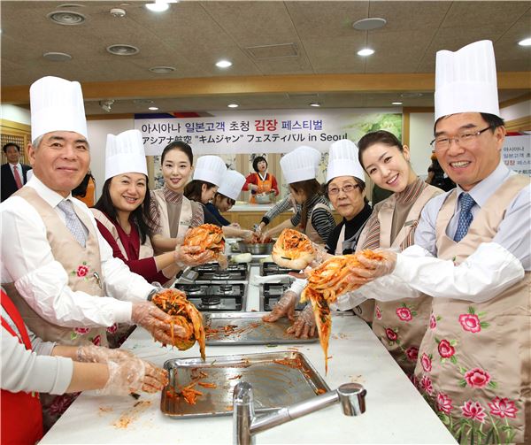 아시아나항공은 12일 서울 필동 ‘한국의 집’에서 일본인 관광객 100여명이 참가한 가운데 김장체험 및 전통문화 공연 관람 행사를 진행했다. 류광희 아시아나항공 여객본부장(오른쪽 첫번째)과 양무승 한국여행업협회 회장(왼쪽 첫번째), 아시아나항공 캐빈승무원들과 일본인 관광객들이 함께 김치를 담그고 있다. 사진=아시아나항공 제공