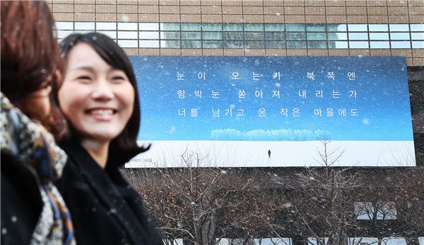서울시내에 첫 눈이 내린 1일 오전 시민들이 교보생명 광화문글판 '겨울편'이 내걸린 광화문 교보생명빌딩 주변을 걷고 있다. 사진=교보생명 제공