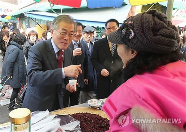 새정치민주연합 대표 경선에 출마한 문재인 후보가 9일 전북 익산시 북부시장을 찾아 상인이 건넨 차를 마시고 있다. 사진=연합뉴스 제공