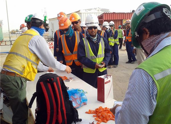 SK건설이 진행 중인 사우디아라비아 와싯(Wasit) 가스플랜트 프로젝트에서 현장에서 안전수칙을 숙지한 근로자들에게 사탕을 나눠주고 있다. 사진=SK건설 제공