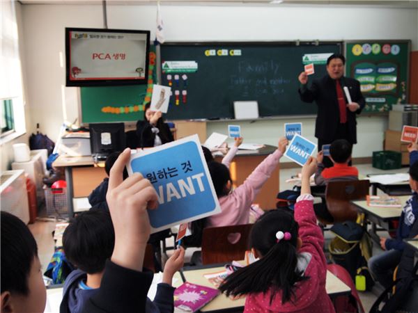 PCA생명이 지난 3일부터 11일까지 서울 시내 9개 초등학교에서 2015년 새해 첫 ‘차칭 밴드와 함께하는 매직넘버 경제 교실을 진행했다. PCA생명의 FC 자원 봉사자가 어린이 경제 교육 애니메이션 ‘차칭’을 활용해 수업을 진행하고 있다. 사진=PCA생명 제공