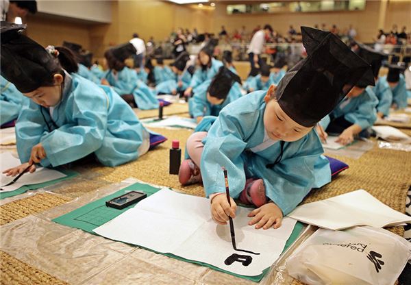 지난 21일 한국스탠다드차타드은행이 진행한 '착한 서당' 프로그램이 성료했다. 사진은 참가한 어린이가 복장을 갖춰입고 붓글씨를 하는 모습. 사진=SC은행 제공.