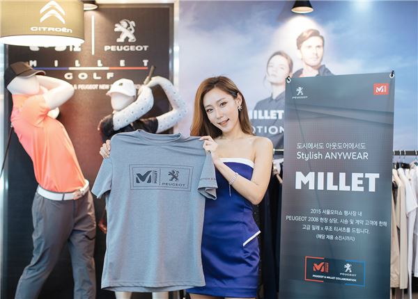 밀레가 2015 서울모터쇼에서 '밀레 골프 라인' 쇼케이스를 진행하며 '푸조 2008' 상담 고객을 대상으로 밀레X푸조 콜래보 아웃도어 티셔츠를 증정한다. 도우미가 경품 티셔츠를 들어보이고 있다. 사진=밀레 제공