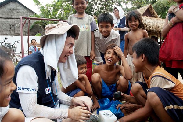 2011년 8월 캄보디아를 방문한 효성 블루챌린저가 적정기술을 활용해 마을어린이들과 함께 사탕수수 부산물로 숯을 만들고 있다. 사진=효성 제공