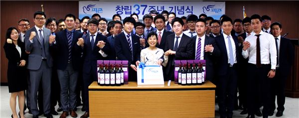 피죤 이주연 대표이사가 37주년 창립기념을 맞아 직원들과 손을 잡고 화이팅을 외치고 있는 모습