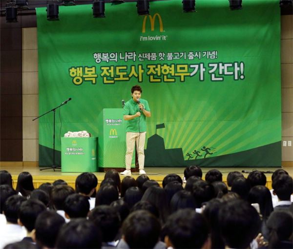 ‘행복의 나라 메뉴 스쿨 어택’ 이벤트로 경기도 덕정고등학교를 찾은 전현무가 학생들에게 행복을 주제로 한 스피치와 꿈과 비전 설계에 대한 이야기를 들려주고 있다.