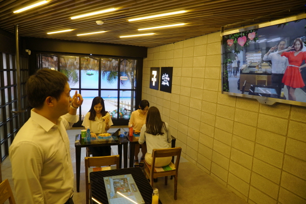 서울 중구 명동에 위치한 세븐일레븐 '스마트 편의점' 매장을 찾은 사람들이 증강현실 기술을 이용한 서비스를 체험하고 있다. 사진=세븐일레븐 제공