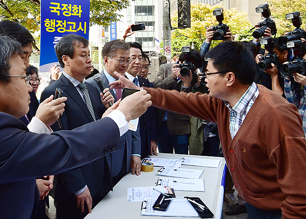 문재인 새정치민주연합 대표가 13일 서울 여의도에서 역사교과서 국정화 반대 서명운동을 벌였으나 보수단체 회원들의 욕설과 고성 등 험악해진 분위기 속에 운동 현장을 철수했다. 사진=이수길 기자 leo2004@