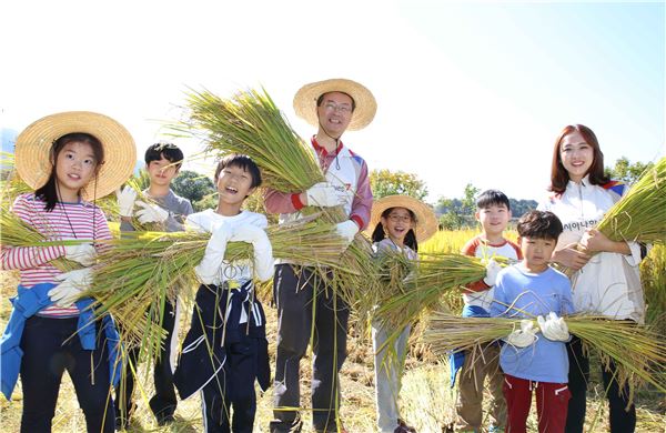 김수천 아시아나항공 사장(왼쪽에서 네번째)이 봉사활동에 참가한 임직원 자녀들과 수확한 벼를 직접 옮기고 있다. 사진=아시아나항공 제공