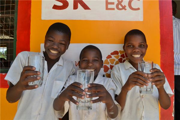 탄자니아 학생들이 SK건설이 기분한 물탱크를 이용해 물을 마시며 행복해 하고 있다. 사진=SK건설 제공