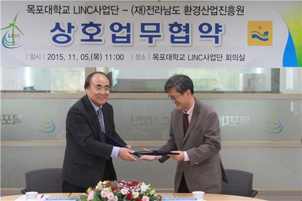 이상돈 목포대 LINC사업단장이 5일 정도영 (재)전남환경산업진흥원장과 협약서를 교환하고 있다.