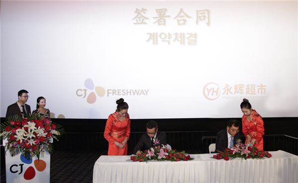 지난 20일 북경 인디고 CGV에서 CJ프레시웨이 강신호 대표(오른쪽)와 영휘마트 장헌송 회장이 양사 합자계약 체결서에 서명하고 있다. 사진=CJ프레시웨이 제공