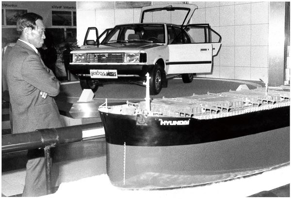 한국종합전시장(KOEX)에 전시된 포니2 모델과 선박 모형 앞에 서있는 아산(1980년대 초). 사진=현대자동차 제공