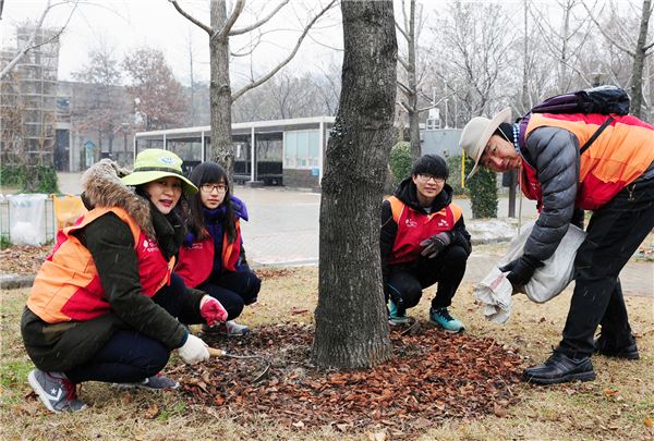 SK건설은 지난 28일 서울 성동구 서울숲에서 겨울철 수목을 보호하기 위한 가족 봉사활동을 실시했다고 밝혔다. 사진은 SK건설 임직원 및 가족 봉사단이 우드칩을 깔아주고 있는 모습. 사진=SK건설 제공