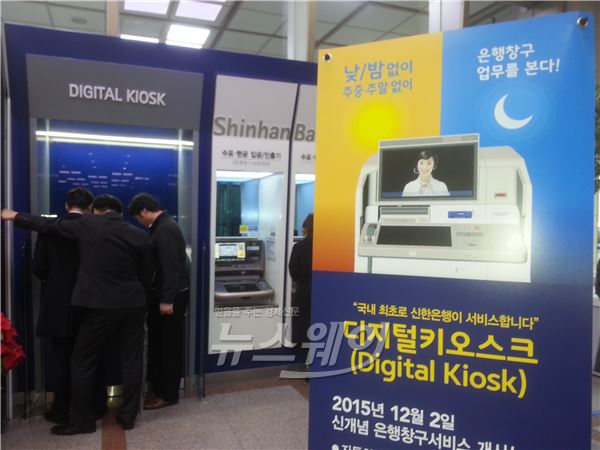 신한은행 본점 1층에 설치된 디지털키오스크기기에 여러 사람이 모여 호기심어린 표정으로 보고 있다. 사진=박종준 기자