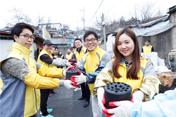 OCI 신입사원과 임원들이 멘토링의 일환으로 서울 중계동 백사마을에서 연탄을 나르고 있다. 사진=OCI 제공