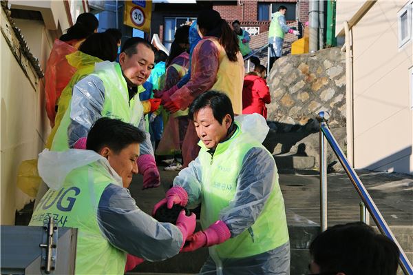 HUG 김선덕 사장(앞줄 오른쪽)을 비롯한 임직원과 대학생 봉사단 40여명이 함께 연탄 나르기 봉사활동을 통해 한해를 마무리 했다. 사진=HUG제공.