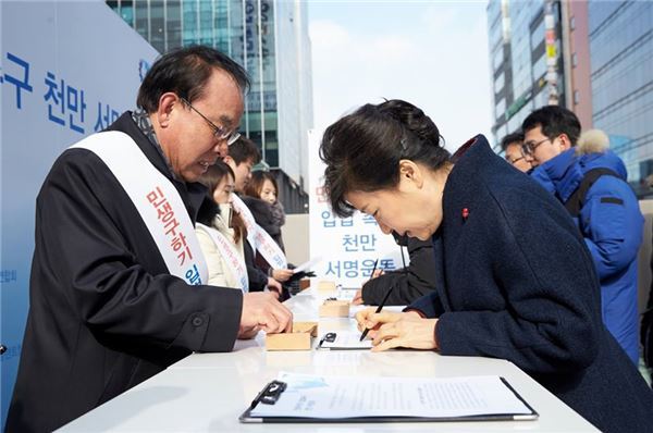 박근혜 대통령이 18일 경기도 판교에서 진행 중인 '민생구하기 입법촉구 천만 서명운동' 부스를 방문해 서명하고 있다. 사진=청와대 제공