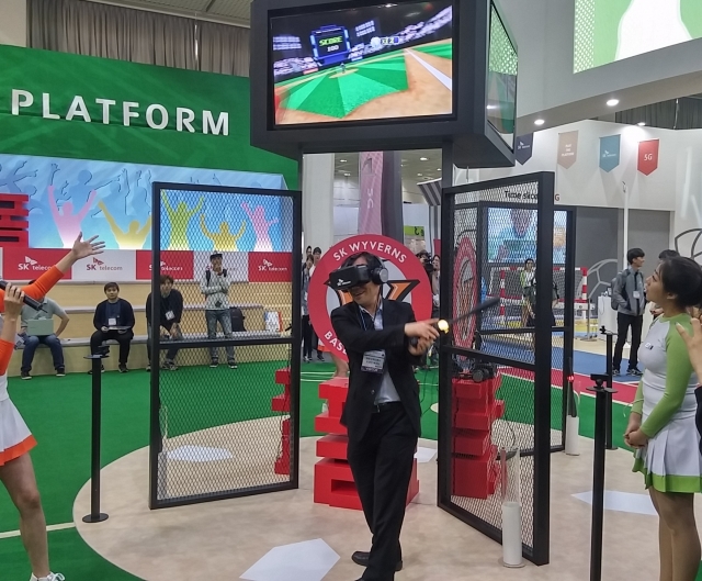 월드 IT쇼2016에 참가한 SK텔레콤이 마련한 전시관에서 IoT 센서가 장착된 VR 기기를 착용하고 야구 체험을 하고 있는 관람객. 사진=한재희 기자