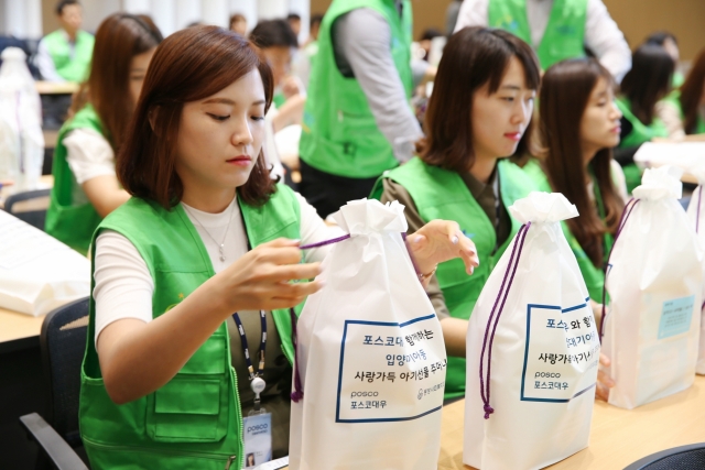 포스코대우 임직원이 입양대기 아기들을 위한 사랑가득 선물주머니를 만들었다. 사진=포스코대우 제공