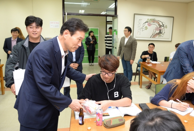 박진성 순천대 총장이 ‘기말고사 간식 나눔 행사’에 참가해 학생들에게 햄버거를 전달하고 있다.