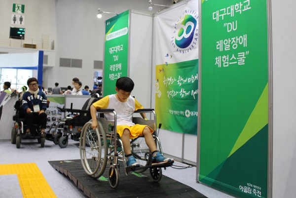 16일 대한민국어울림축전 행사에 참가한 학생들이 휠체어를 타고 경사로를 오르는 장애체험을 하고 있다.