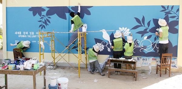 계명대 국외봉사단이 현지 학교 건물 외벽을 보수한 후 벽화 작업을 하고 있다.