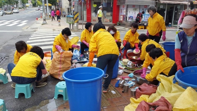 고흥군 여성단체협의회원들이 11일 태풍 차바로 큰 피해를 입은 울산시 중구 우정 재래시장 쓰레기 제거에 구슬땀을 흘리고 있다.