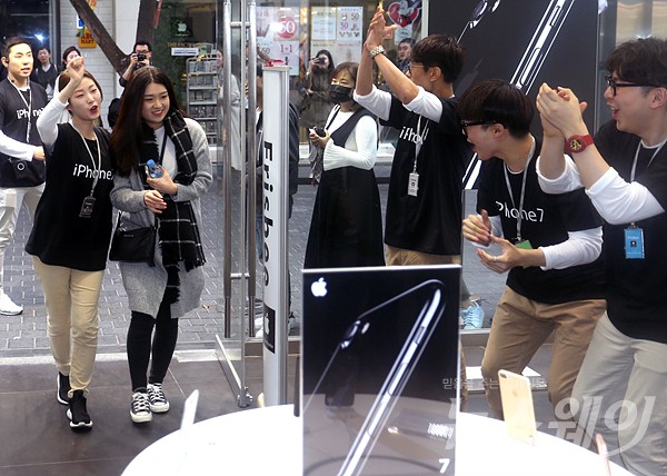 아이폰7이 출시된 21일 오전 서울 중구 명동 프리스비매장에서 1등으로 구매하게 된 한 여성 고객이 직원들의 축하를 받으며 입장을 하고 있다. 사진=최신혜 기자 shchoi@newsway.co.kr