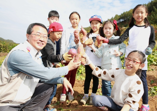 김수천 아시아나항공 사장(왼쪽 첫 번째)이 임직원 자녀들과 함께 캔 고구마를 들어보이고 있다. 사진=아시아나항공 제공