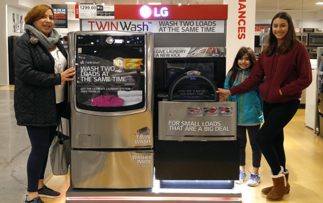 미국 뉴저지주의 한 가전 매장에서 소비자들이 LG 트윈워시 앞에서 웃고 있다. 사진=LG전자 제공.