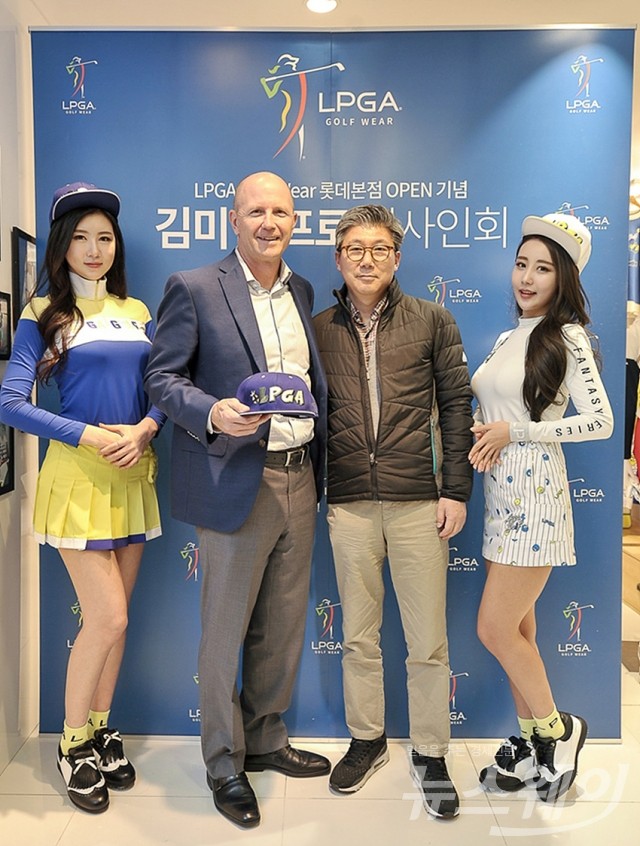 모델들과 기념촬영하는 존 포대니 LPGA 협회 부총재와 김문환 엠케이트렌드 사장