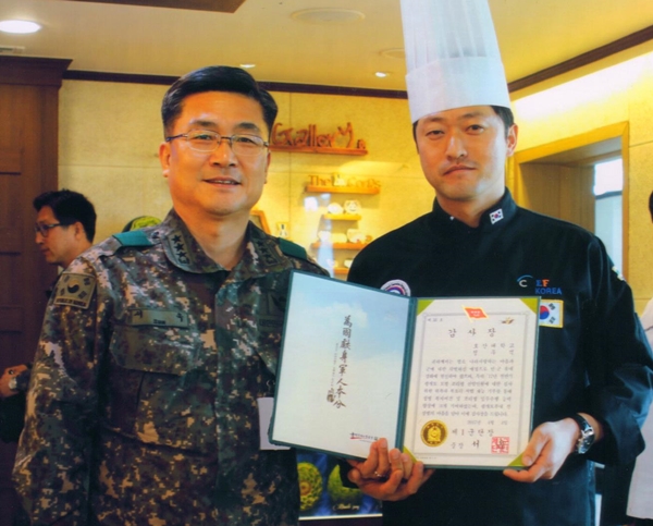 호산대 호텔외식조리과 정우석 교수(오른쪽)가 요리경연대회장에서 1군단장인 서 욱 중장과 기념 촬영을 하고 있다. (사진제공=호산대)