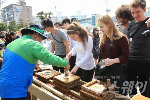 외국인 관람객들이 전통 재래 김뜨기 체험을 하며 즐거워 하고 있다.