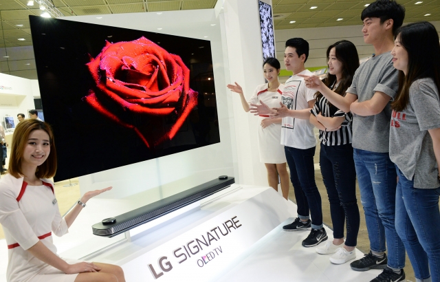 LG전자 부스를 찾은 관람객들이 ‘LG 시그니처 올레드 TV W’를 살펴보고 있다. 사진=LG전자 제공