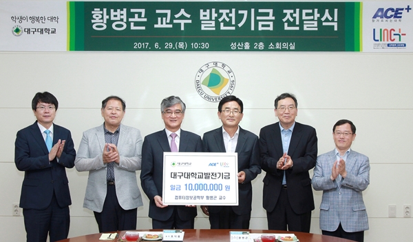대구대 황병곤 교수(왼쪽에서 네번째)와 홍뎍률 총장(왼쪽에서 세번째)이 대학발전기금 전달식을 갖고, 참석자들과 기념촬영을 하고 있다.(사진제공=대구대)