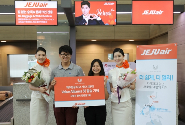 제주항공은 밸류 얼라이언스 첫 탑승객으로 기록된 김광민씨와 김윤주씨 남매에게 축하 꽃다발과 함께 제주항공 국내선 왕복항공권을 증정했다. 사진=제주항공 제공