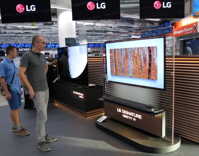 LG전자 모델들이 인공지능 스피커 ‘아마존 에코’를 통해 LG 올레드 TV를 제어하는 시연을 하고 있다. 사진=LG전자 제공