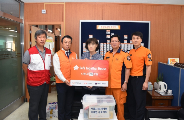 지난 8일 한화손해보험 강동지역봉사단 단원들이 서울 강동소방서에서 화재 피해를 입은 이재민에게 위로금과 구호물품을 전달하고 있다.