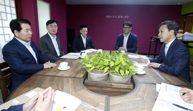 지난 12일 김승수(오른쪽) 전주시장이 시청을 방문한 부영그룹 봉태열(왼쪽) 고문, 이기홍(왼쪽에서 두번째) 사장 일행과 부영아파트 임대료 인상률 등 현안에 대해 논의하고 있다. 사진=전주시 제공.