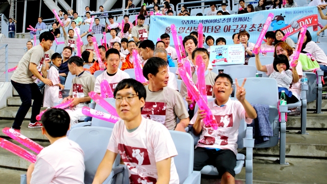 우리카드가 12일 서울 고척돔에서 진행한 ‘수퍼마일데이’ 행사에 초청 받은 홀트일산복지타운 소속 장애인들이 프로야구단 넥센 히어로즈의 홈경기를 관람하고 있다.