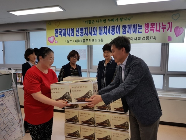 한국마사회 선릉지사 김광만 지사장(오른쪽)이 15일 수혜주민에게 선물을 증정하고 있다.