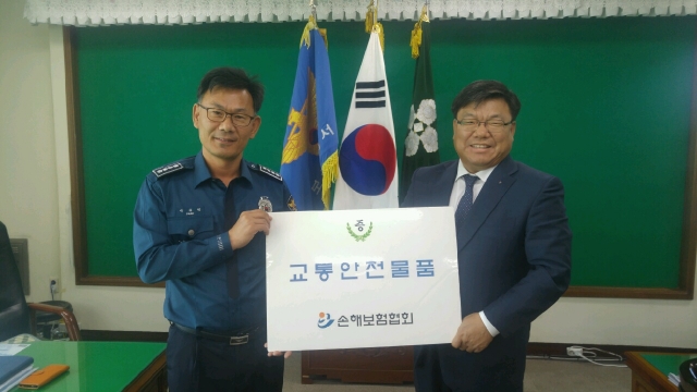 손보협회 호남본부 김양식 본부장(오른쪽)이 13일 보성경찰서 박석규 서장(왼쪽)에게 교통안전물품을 전달하고 있다.