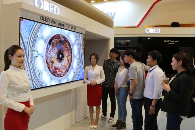 IMID 2017에 참가한 관람객들이 LG디스플레이 부스에서 77인치 UHD 월페이퍼 OLED를 감상하고 있는 모습. 사진=LG디스플레이 제공.