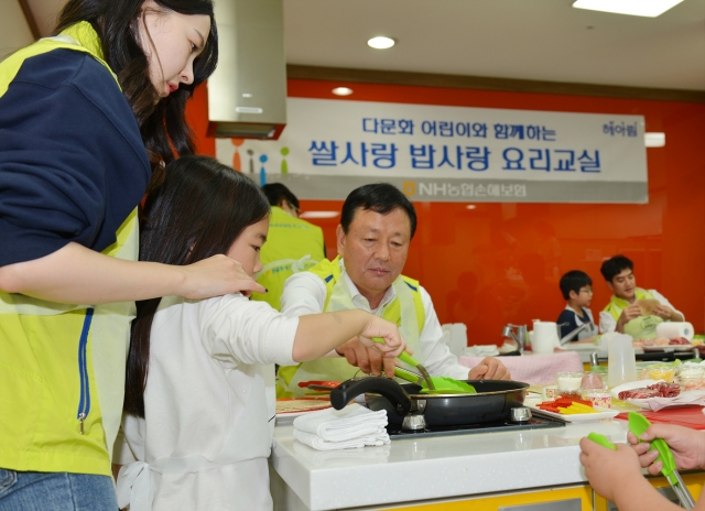 NH농협손해보험이 23일 농협 쌀박물관에서 진행한 ‘쌀사랑 밥사랑 요리교실’ 행사에 참여한 오성근 전략총괄부문장과 헤아림봉사단이 다문화가정 아동들과 쌀 요리를 만들고 있다.