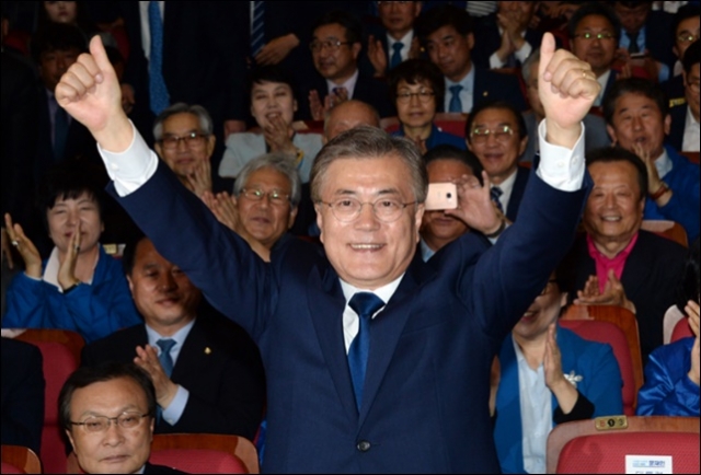 문재인 대통령이 지난 5월 10일 대선 투표결과를 확인한 후 두 손을 높이 든 모습. 사진=더불어민주당 제공