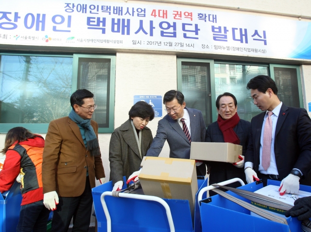 CJ대한통운(대표이사 사장 박근태)은 27일 서울시 송파구 양산로에 위치한 장애인직업재활시설 ‘임마누엘’에서 서울시, 장애인직업재활시설협회와 함께 ‘발달장애인 택배사업단 발대식’을 개최했다고 27일 밝혔다. 행사 중 남인순 더불어민주당 의원(송파 병,왼쪽 두번째)과 신동휘 CJ대한통운 부사장(왼쪽 세번째), 박인섭 송파구의회 부의장(왼쪽 네번째) 등 관계자들이 택배 체험을 해보고 있다. 사진=CJ대한통운 제공