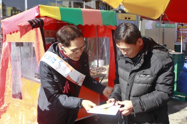 윤석군본부장(사진왼쪽)이 13일 광주송정시장에서 농지연금 팜플렛을 나눠주고 있다.