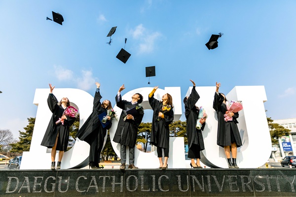 학위수여식이 열린 23일 대구가톨릭대 캠퍼스에서 졸업생들이 DCU조형물을 배경으로 기념 촬영을 하고 있다.(사진제공=대구가톨릭대)